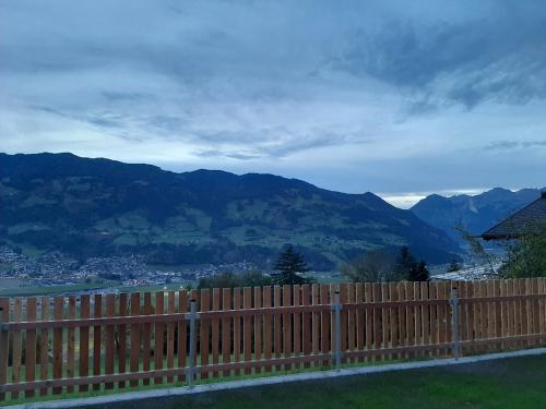 a wooden fence with mountains in the background at Apart Leonie in Hart im Zillertal