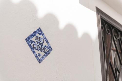 a sign on the side of a white wall at Hostal Pons in Palma de Mallorca