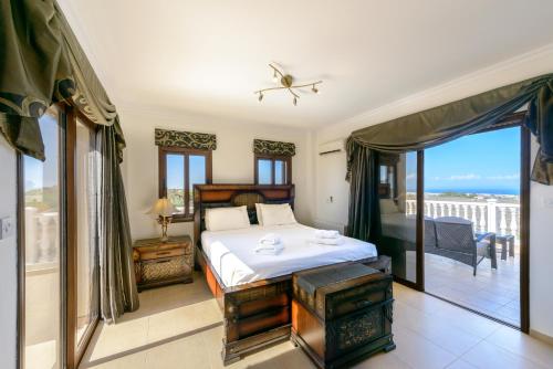 Un dormitorio con una cama y un balcón. en Amani Villa, en Protaras