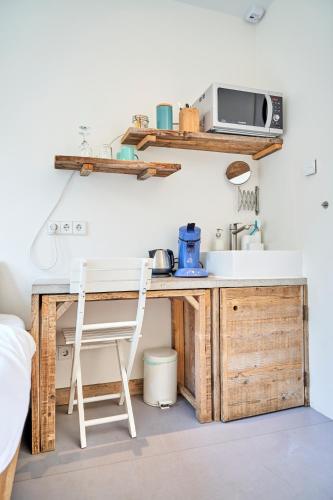 a kitchen with a desk and a microwave on a wall at The Amsterdam Houseboat Family - de Pijp in Amsterdam