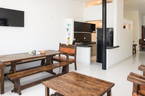 a kitchen with wooden tables and a black refrigerator at Hotel Boutique San Rafael in Mariquita