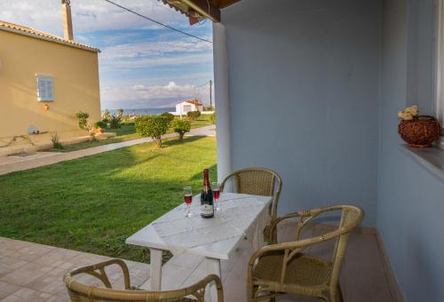 a white table with two glasses of wine on a patio at Beachside Bungalows Acharavi Corfu in Acharavi