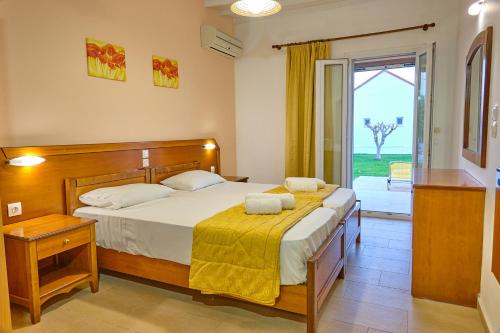 a bedroom with a bed and a large window at Beachside Bungalows Acharavi Corfu in Acharavi