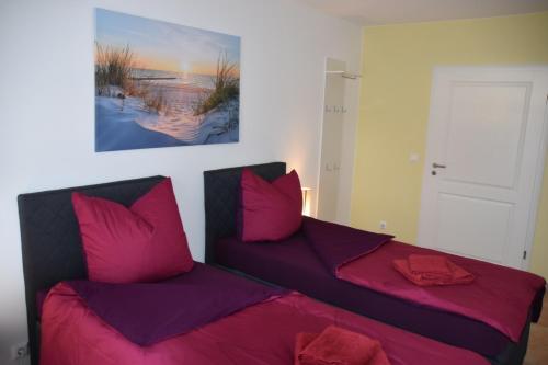 1 dormitorio con 2 camas y almohadas rosas en FeWo-Airport, en Blankenfelde