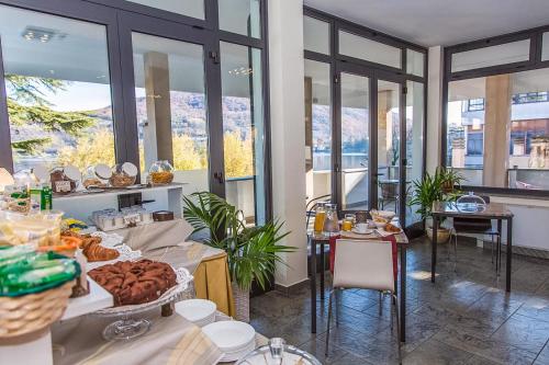 Hotel Chalet del Lago في أفيليانا: غرفة إفطار مع طاولة عليها طعام