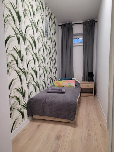 ein Schlafzimmer mit einem Bett und einem Wandbild in der Unterkunft Apartamenty Cieplicka 20 in Jelenia Góra
