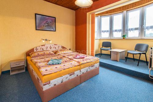a bedroom with a bed and a table and chairs at Pension ASTORIA in Klášterec nad Ohří