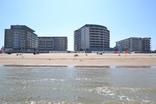 a beach with two tall buildings in the background at Vayamundo Oostende in Ostend