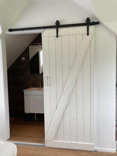 a sliding barn door in a room at Vakantiehuis Ervedriestreek in Den Ham