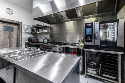 a large stainless steel kitchen with a stove and microwave at Pension ASTORIA in Klášterec nad Ohří
