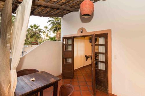 a room with a table and a wooden door at Hotel 1697 Loreto in Loreto