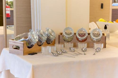 Una mesa con un montón de vasos y cucharas de plata. en Appartamento Campagnola 1, en Riva del Garda