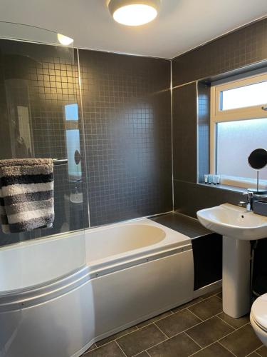 La salle de bains est pourvue d'une baignoire et d'un lavabo. dans l'établissement Bedlington apartment, à Bedlington