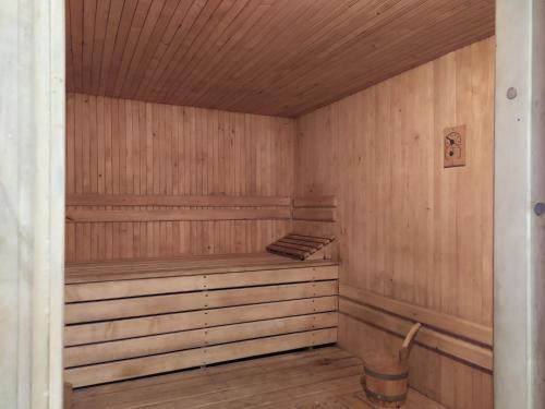 a wooden sauna with a bench and a bucket in it at Domek na wzgórzu Blanki in Lidzbark Warmiński