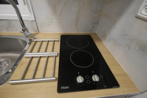uma placa de fogão preta com um lavatório na cozinha em Appartement cosy entre mer et ville avec parking gratuit a proximite em Netanya