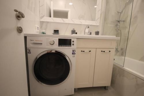 a washing machine in a bathroom with a sink at Appartement cosy entre mer et ville avec parking gratuit a proximite in Netanya