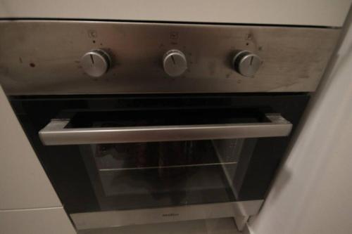 an oven with two knobs on top of it at Appartement cosy entre mer et ville avec parking gratuit a proximite in Netanya