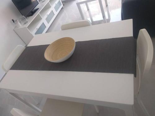 a white table with a wooden bowl on top of it at Appartement cosy entre mer et ville avec parking gratuit a proximite in Netanya