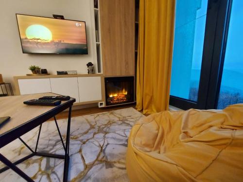 a living room with a fireplace and a tv at Apartman Bjelašnica in Bjelašnica