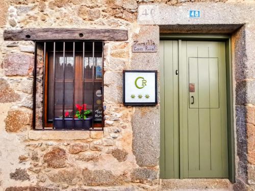 un edificio con una puerta verde y una ventana en Zocailla, en Gata