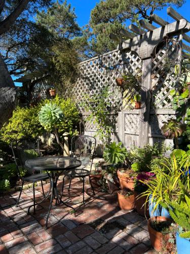 Carmel Garden Inn في كرمل: فناء مع طاولة وكراسي والنباتات الفخارية