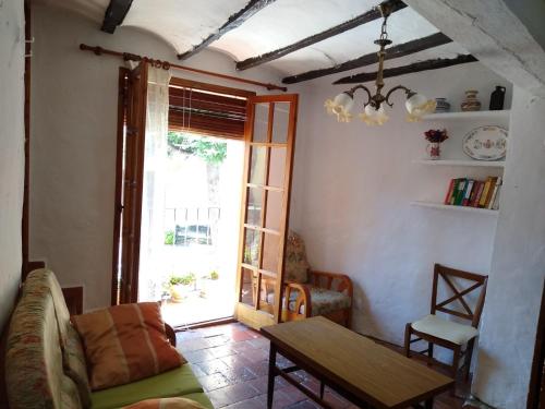 sala de estar con sofá, mesa y ventana en Casa de Amparo y José Manuel, en Pavías