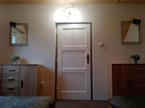 a bedroom with a door and a light on the wall at UBYTOVÁNÍ S WELLNESS in Dolní Dobrouč