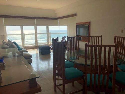 a living room with a dining room table with a view of the ocean at Mayan Vidanta Playa Departamento 3 Recamaras varias albercas in Acapulco