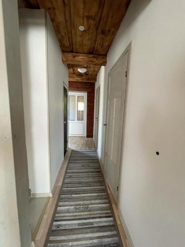 a hallway with a wooden ceiling and a hallway with white walls at Sauna ja nelja magamistoaga Kasemäe puhketalu in Tealama