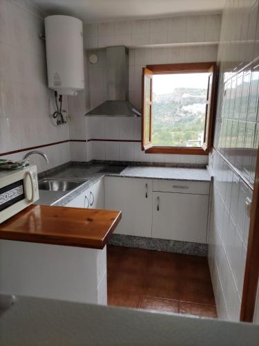 a small kitchen with a sink and a window at Apartamentos "La Rueda" in Chulilla