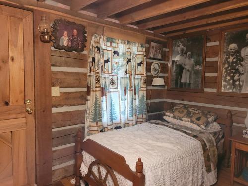 a bedroom with a bed in a room with wooden walls at Mountain Memories Cabin Rental in Booneville