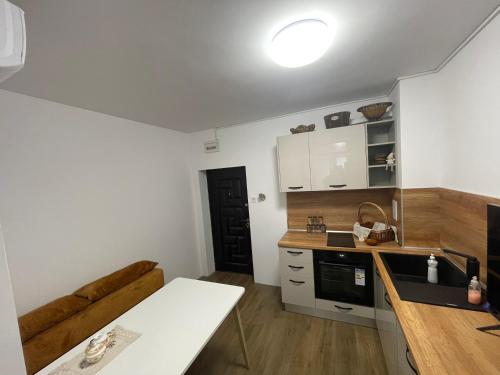 a small kitchen with a table and a couch at DeTY's Apartment in Burgas City