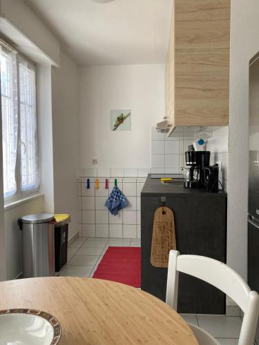une cuisine avec une table et un comptoir dans l'établissement TANGO appartement de charme calme 75m2 6 personnes, à Mulhouse