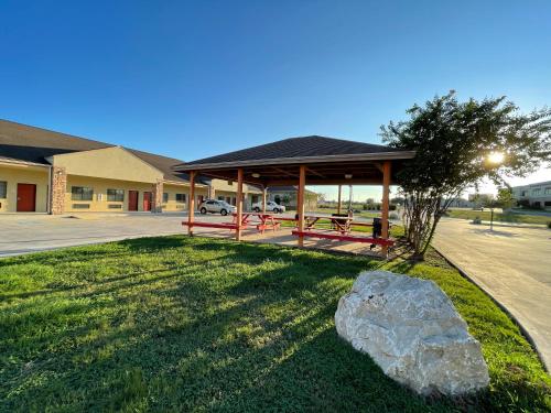 a building with a gazebo and a rock at Sunbridge Inn & Suite Extended Stay in Jourdanton