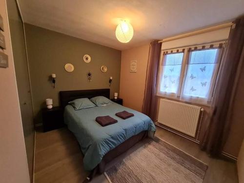 een slaapkamer met een bed met twee handdoeken erop bij Chez Romain, appartement proche commerces et centre ville in Verdun-sur-Meuse