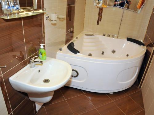 a bathroom with a bath tub and a sink at Guesthouse Elizabeth in Samokov