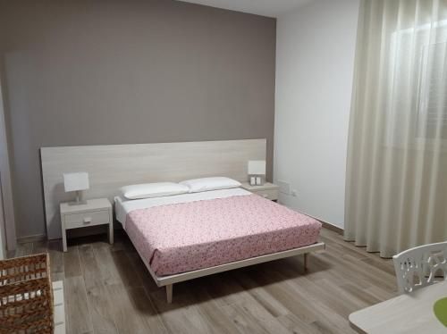 ein weißes Schlafzimmer mit einem Bett und zwei Nachttischen in der Unterkunft Dimora Pianelle in Crispiano