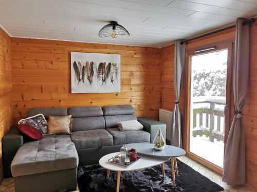 ein Wohnzimmer mit einem Sofa und einem Tisch in der Unterkunft Chalet chaleureux au cœur du massif du haut Jura in Mignovillard