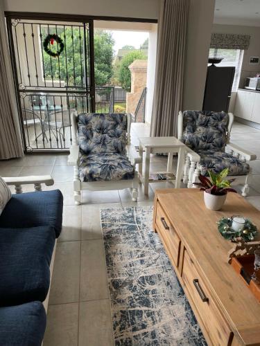 a living room with two chairs and a coffee table at Ruebys Apartment 202 in Dullstroom