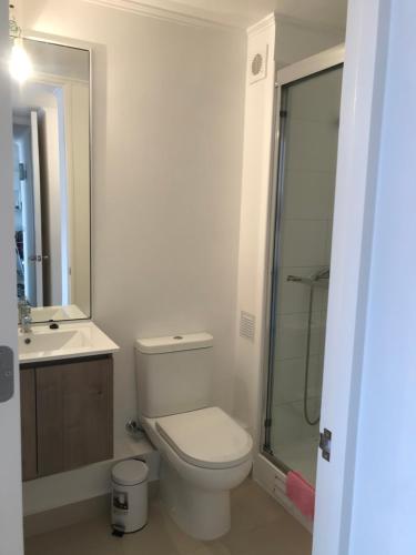 a bathroom with a toilet and a glass shower at Departamento Pacífico 2800-Reserva Mínima de 3 días in La Serena