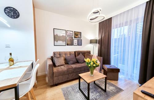 een woonkamer met een bank en een tafel bij LAGUNA Apartament Polanica Residence 41 in Polanica-Zdrój