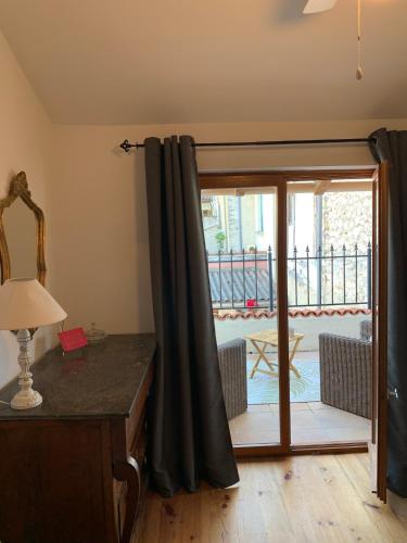 a room with a sliding glass door to a balcony at Maison cosy cœur de bastide+ cour + vue sur toits in Eymet