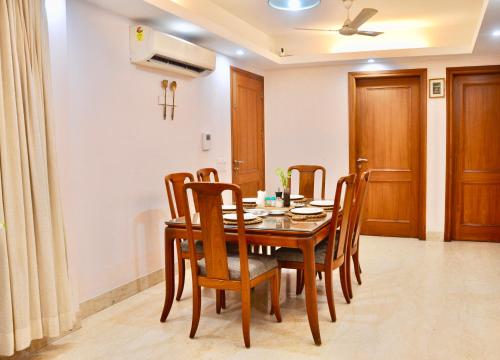 - une salle à manger avec une table et des chaises en bois dans l'établissement Aashianaa Gracious Living, à New Delhi