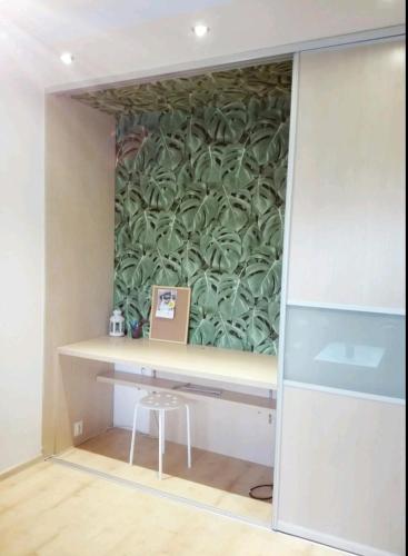 a room with a desk with a green wall at Zaspa Apartament in Gdańsk