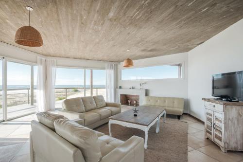 a living room with a couch and a table at MarAdentro Apart Hotel & Suites in Punta Del Diablo