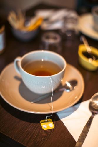 une tasse de thé sur une assiette sur une table dans l'établissement LA MAISON DE NACRE, à Douvres-la-Délivrande