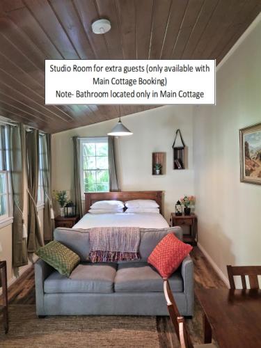 a bedroom with a bed with a couch at Jacomb's Cottage and Studio in Walhalla