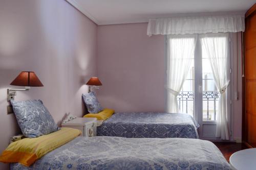 a bedroom with two beds and a window at Apartamento céntrico, parking gratis in Santander