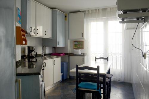 a kitchen with white cabinets and a table and chairs at Apartamento céntrico, parking gratis in Santander
