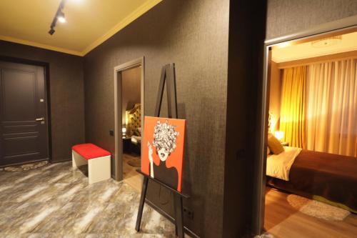 a room with a bed and a painting on the wall at Apartments Lux in city center Lviv in Lviv